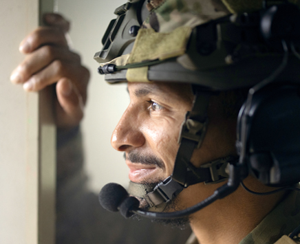 Birmingham Police Officer in tactical gear looking out of a window while smiling