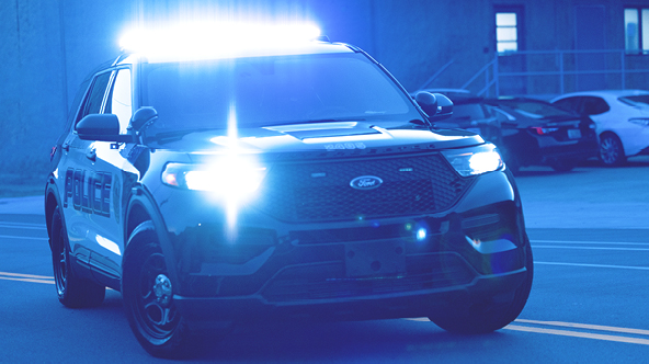 A Birmingham Police Department patrol car turning onto a road with it's police lights engaged